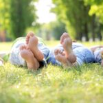 Earthing - family lying on the grass with bare feet